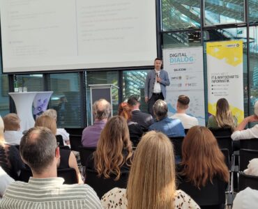 Speaker auf der Bühne vor Publikum beim Digitaldialog