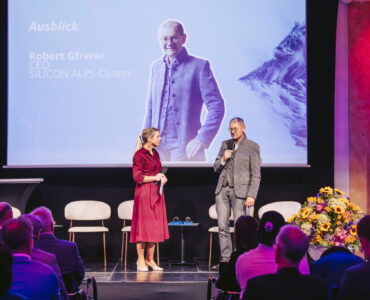 Robert Gfrerer mit Moderatorin auf der Bühne vor Publikum