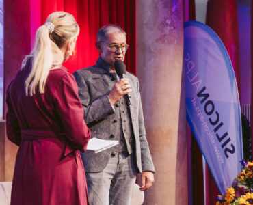 Robert Gfrerer und Moderatorin auf der Bühne von 10 Jahre SILICON ALPS