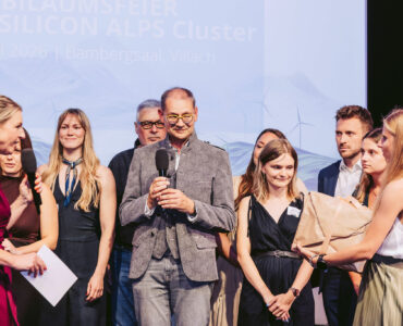 Team SILICON ALPS auf der Bühne und Überreichung eines Geschenks